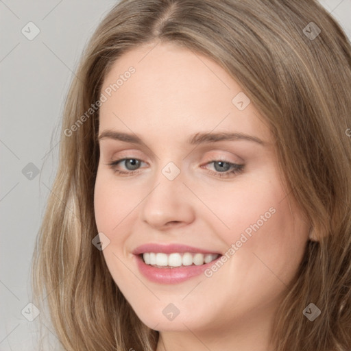 Joyful white young-adult female with long  brown hair and grey eyes