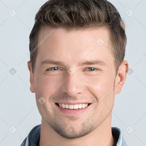 Joyful white young-adult male with short  brown hair and grey eyes