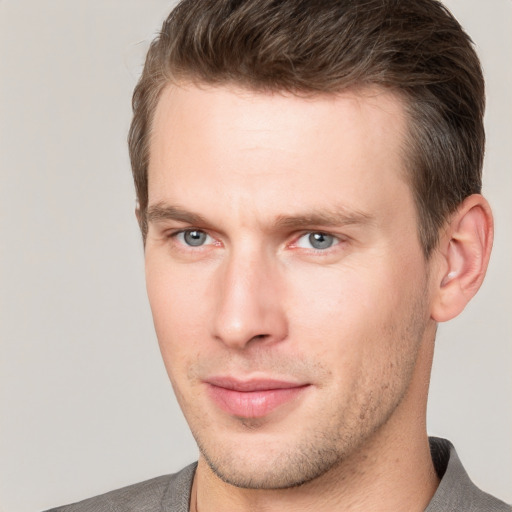 Joyful white young-adult male with short  brown hair and grey eyes