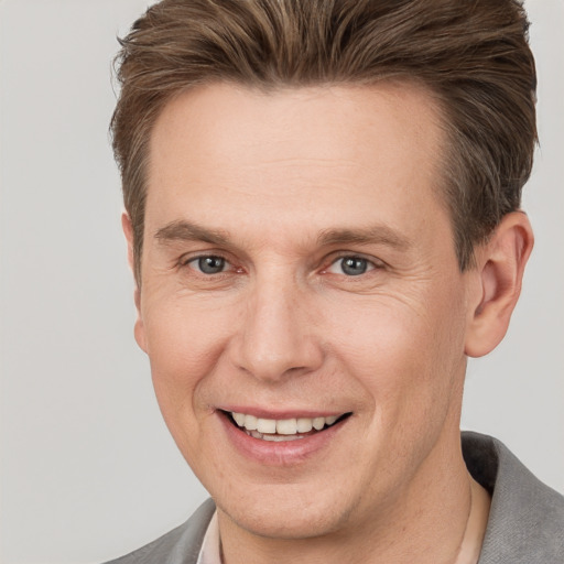 Joyful white adult male with short  brown hair and grey eyes