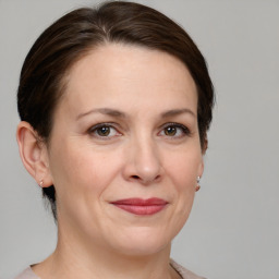 Joyful white adult female with medium  brown hair and grey eyes