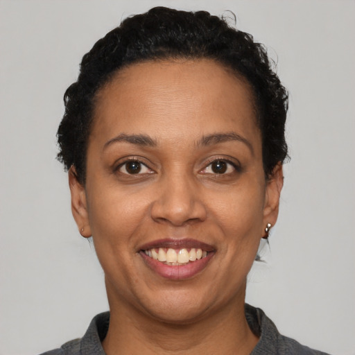 Joyful black adult female with short  black hair and brown eyes
