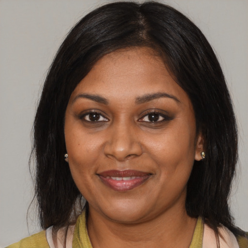 Joyful black young-adult female with medium  brown hair and brown eyes