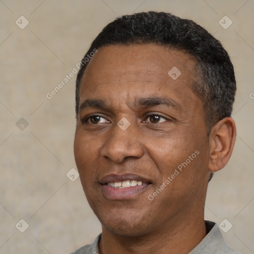 Joyful black adult male with short  black hair and brown eyes