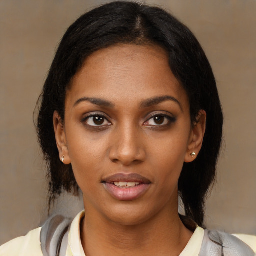 Joyful black young-adult female with medium  brown hair and brown eyes