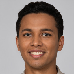 Joyful latino young-adult male with short  brown hair and brown eyes