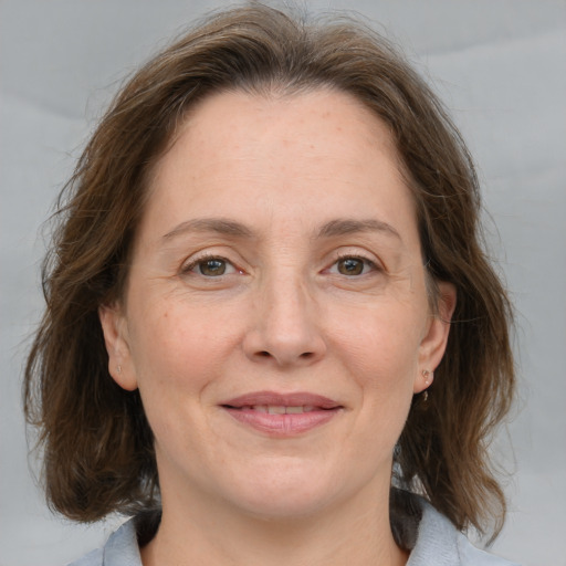 Joyful white adult female with medium  brown hair and grey eyes