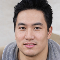 Joyful asian young-adult male with short  black hair and brown eyes