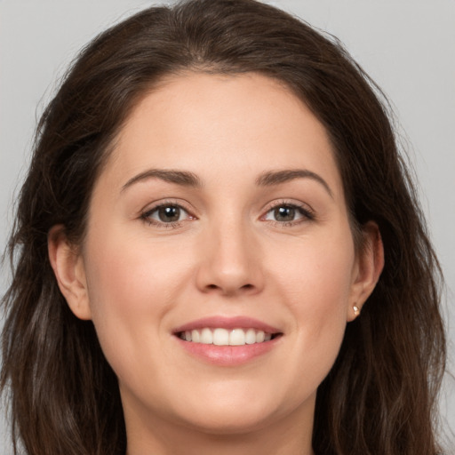 Joyful white young-adult female with long  brown hair and brown eyes