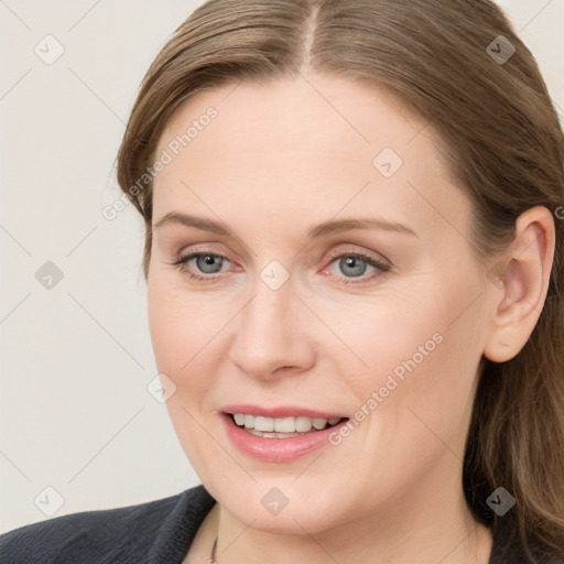 Joyful white young-adult female with long  brown hair and blue eyes