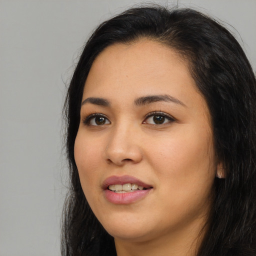 Joyful latino young-adult female with long  black hair and brown eyes