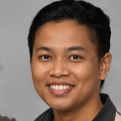 Joyful latino young-adult male with short  brown hair and brown eyes