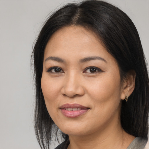 Joyful asian adult female with long  brown hair and brown eyes