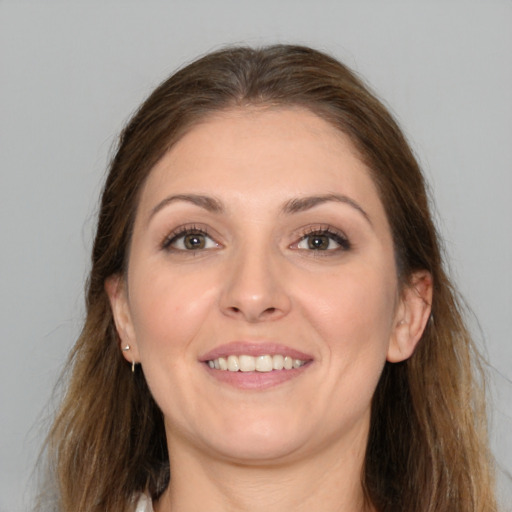 Joyful white young-adult female with long  brown hair and brown eyes