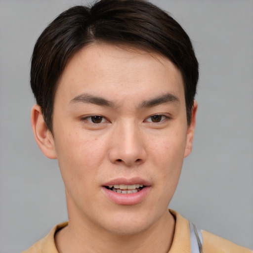 Joyful asian young-adult male with short  brown hair and brown eyes