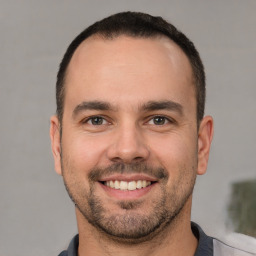 Joyful white young-adult male with short  brown hair and brown eyes