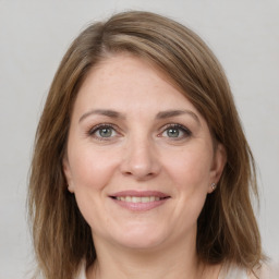 Joyful white adult female with medium  brown hair and grey eyes