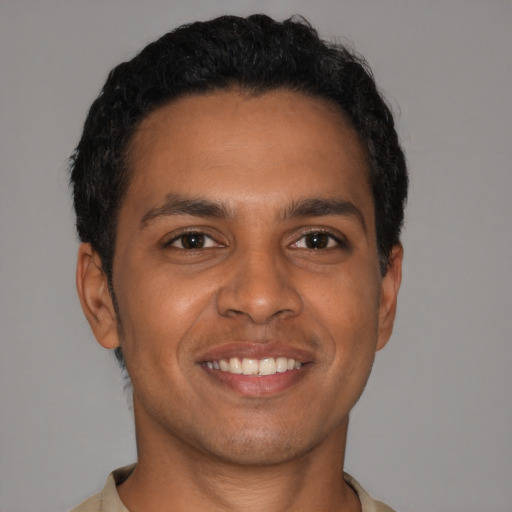 Joyful latino young-adult male with short  brown hair and brown eyes
