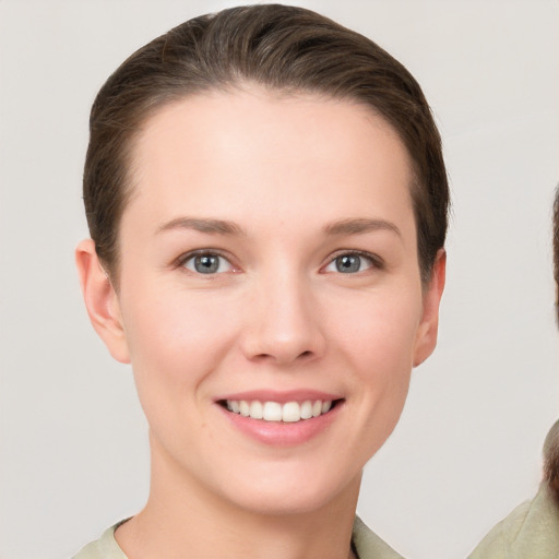 Joyful white young-adult female with short  brown hair and grey eyes