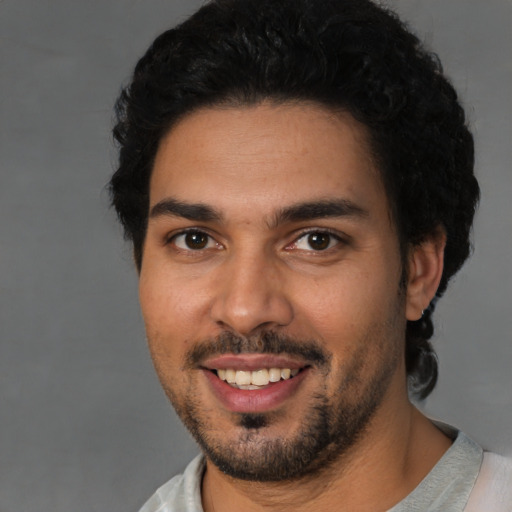 Joyful latino young-adult male with short  black hair and brown eyes