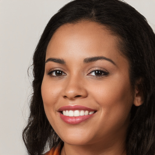 Joyful latino young-adult female with long  brown hair and brown eyes