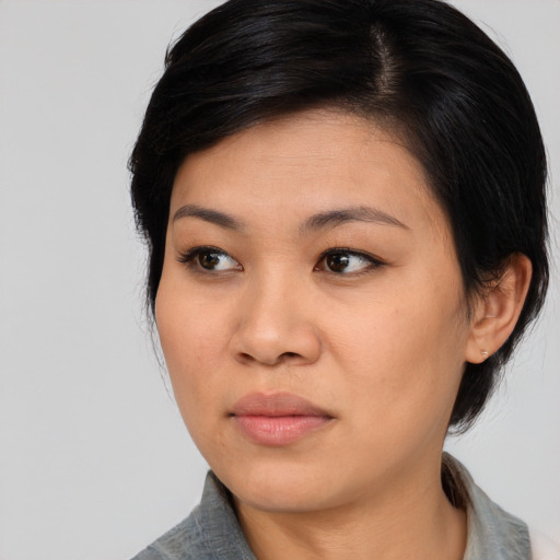 Joyful asian young-adult female with medium  black hair and brown eyes