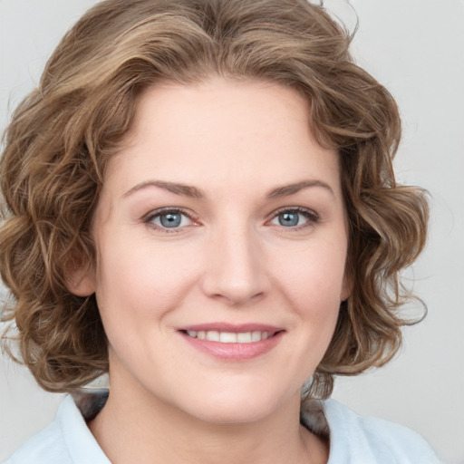 Joyful white young-adult female with medium  brown hair and blue eyes