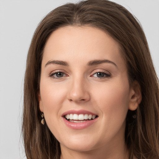 Joyful white young-adult female with long  brown hair and grey eyes