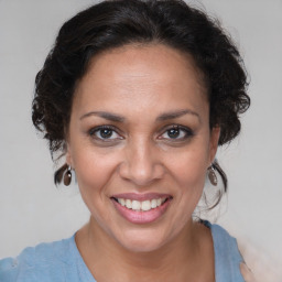 Joyful latino adult female with medium  brown hair and brown eyes