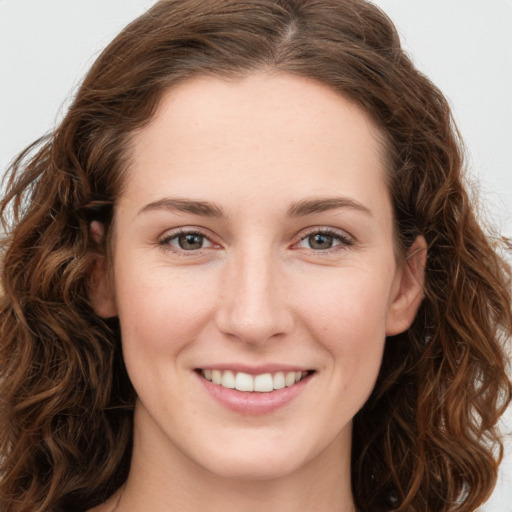 Joyful white young-adult female with long  brown hair and green eyes