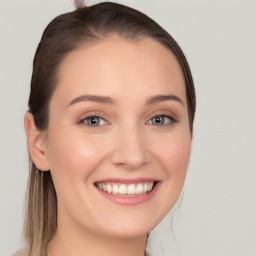 Joyful white young-adult female with long  brown hair and blue eyes