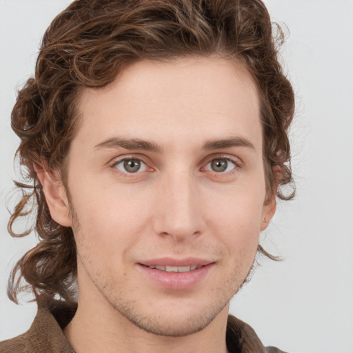 Joyful white young-adult male with medium  brown hair and green eyes