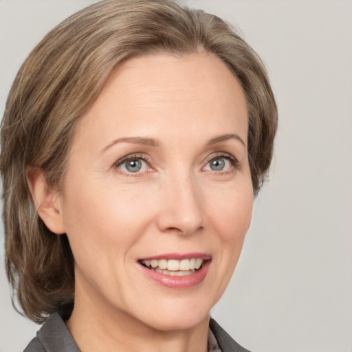 Joyful white adult female with medium  brown hair and grey eyes