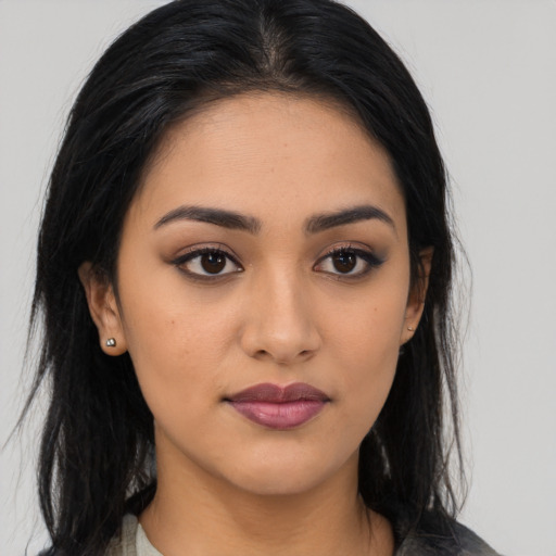Joyful latino young-adult female with long  black hair and brown eyes