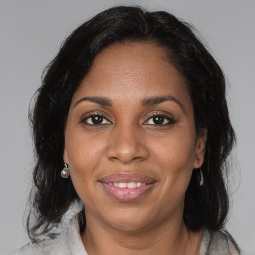 Joyful black adult female with medium  black hair and brown eyes