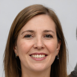 Joyful white adult female with long  brown hair and grey eyes