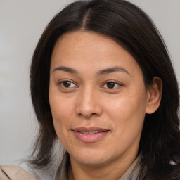 Joyful latino adult female with medium  brown hair and brown eyes