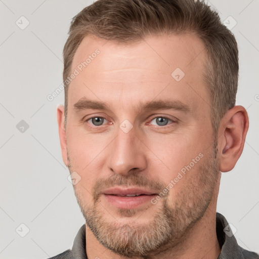 Joyful white adult male with short  brown hair and grey eyes