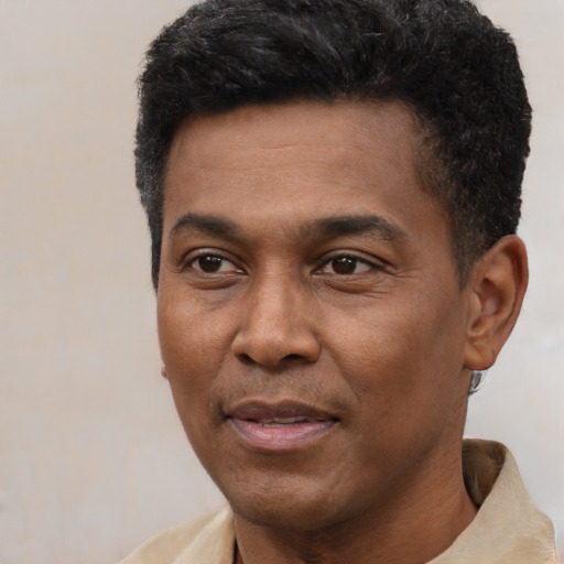 Joyful black adult male with short  black hair and brown eyes