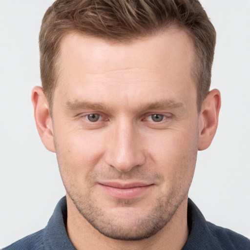 Joyful white young-adult male with short  brown hair and grey eyes