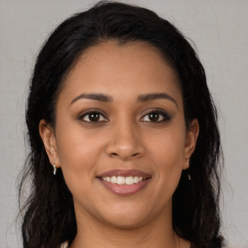 Joyful latino young-adult female with long  brown hair and brown eyes