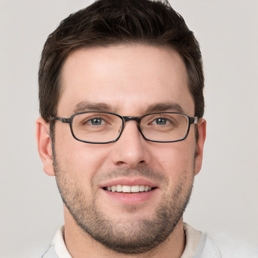 Joyful white young-adult male with short  brown hair and grey eyes