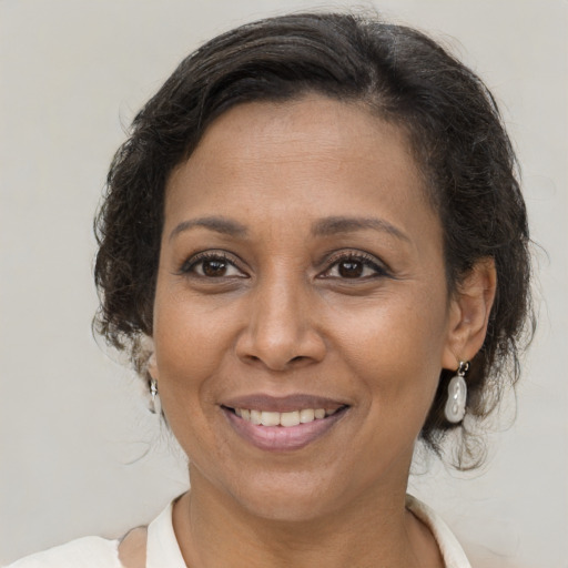 Joyful black adult female with medium  brown hair and brown eyes