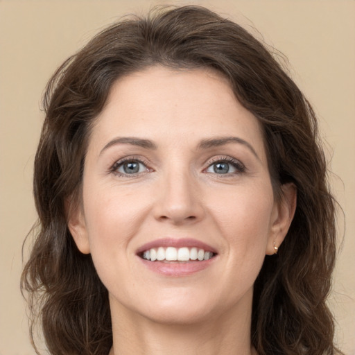 Joyful white young-adult female with long  brown hair and green eyes