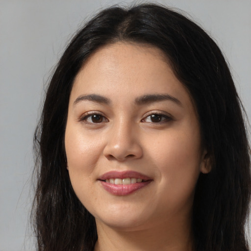 Joyful latino young-adult female with long  brown hair and brown eyes