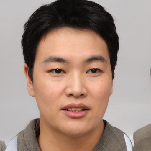 Joyful asian young-adult male with short  black hair and brown eyes