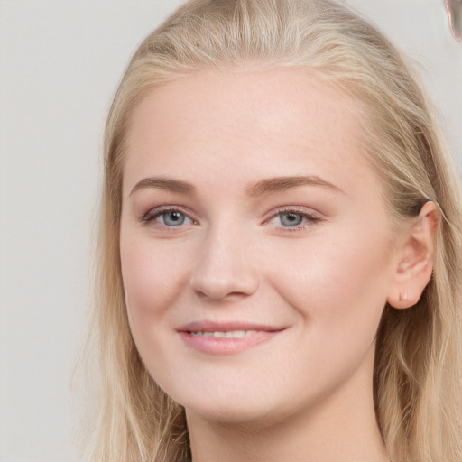 Joyful white young-adult female with long  brown hair and blue eyes