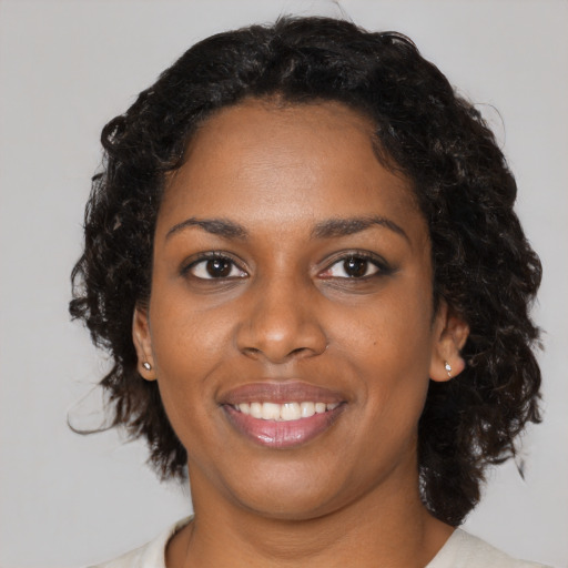 Joyful black young-adult female with medium  black hair and brown eyes