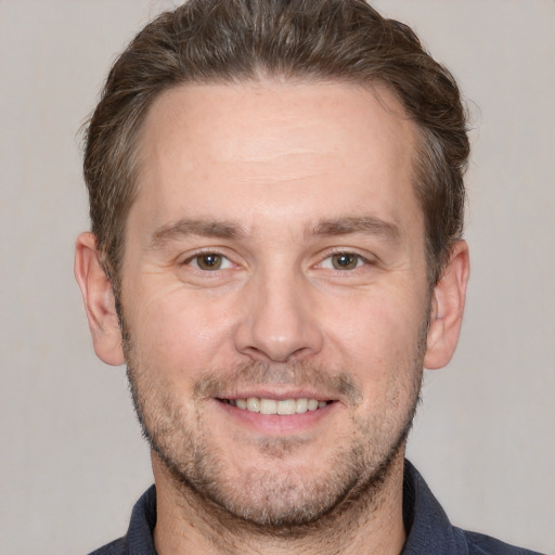 Joyful white adult male with short  brown hair and brown eyes