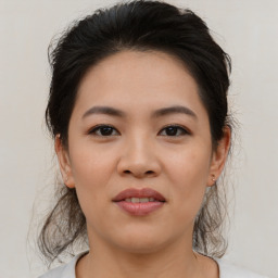 Joyful asian young-adult female with medium  brown hair and brown eyes